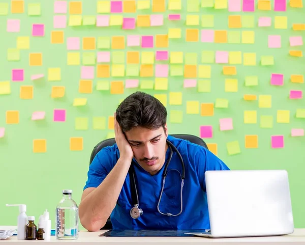 Giovane medico con molti promemoria e lavoro urgente — Foto Stock