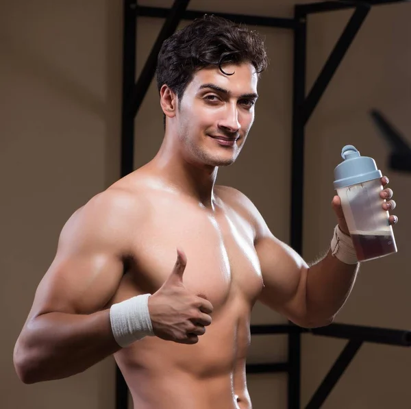 Uomo con integratori nutrienti in palestra sportiva — Foto Stock