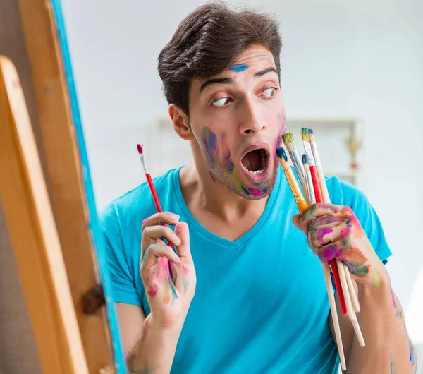 Joven artista divertido trabajando en la nueva pintura en su estudio — Foto de Stock