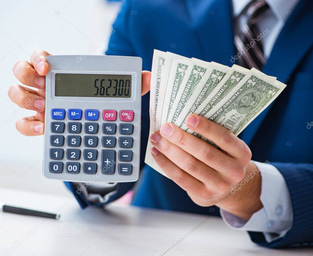 Accountant calculating dollars with calculator in office