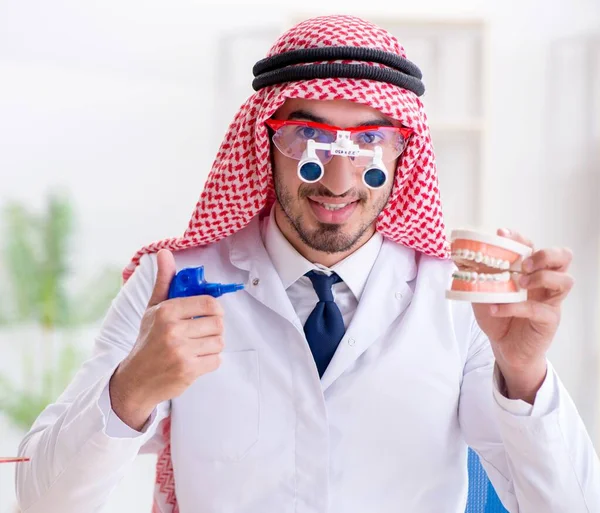 Odontólogo árabe trabajando en un nuevo implante dental — Foto de Stock