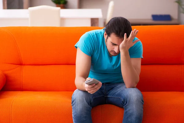 Joven estudiante masculino viendo televisión en el interior — Foto de Stock