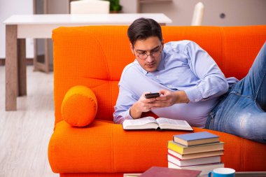 Evde sınava hazırlanan genç bir erkek öğrenci.