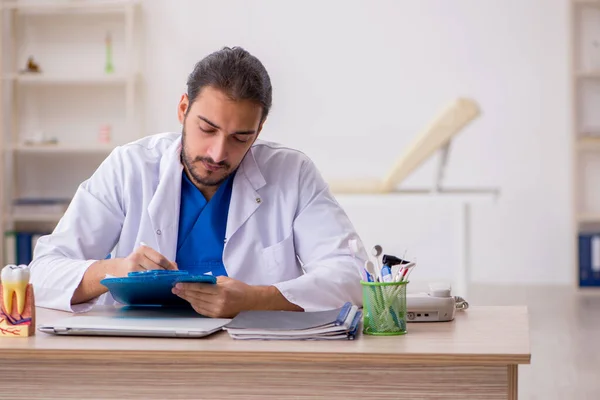 Junger männlicher Zahnarzt arbeitet in der Klinik — Stockfoto