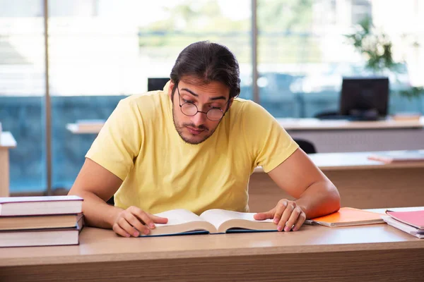 Jonge mannelijke student bereidt zich voor op examens in de klas — Stockfoto