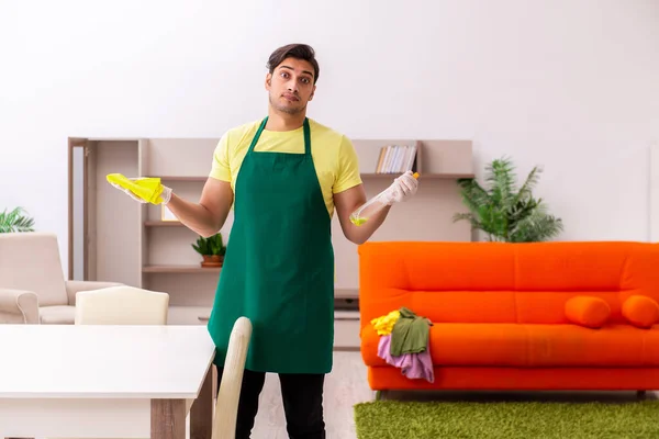 Joven contratista masculino limpiando la casa en interiores — Foto de Stock