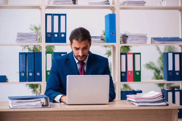 Jeune employé masculin et trop de travail au bureau — Photo