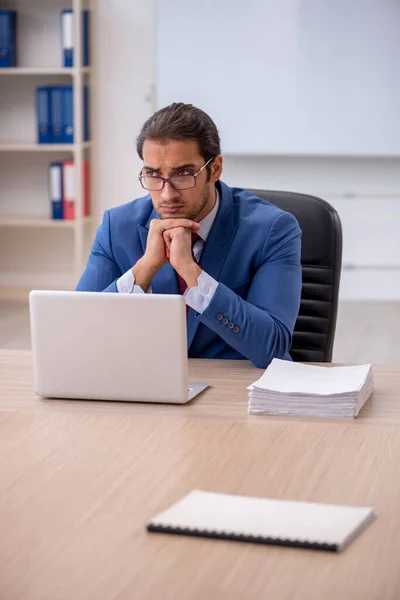 Jovem funcionário do sexo masculino sentado no escritório em frente ao quadro branco — Fotografia de Stock
