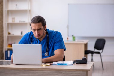 Klinikte çalışan genç erkek doktor.