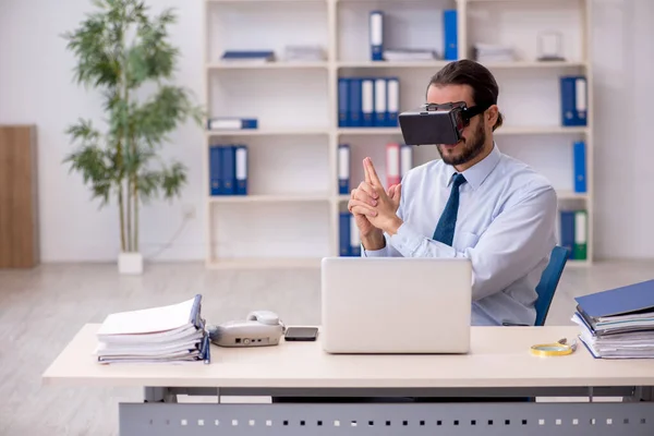 Jovem funcionário masculino vestindo óculos virtuais no local de trabalho — Fotografia de Stock