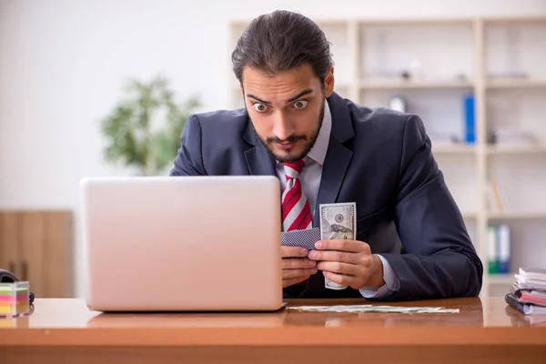 Young male employee playing cards at workplace