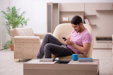 Salgın sırasında evde oturan genç adam.