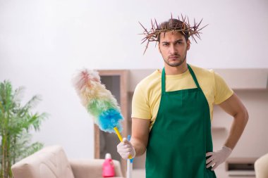 Genç erkek müteahhit, baş temizleme yerine dikenli çelenk giyiyor.