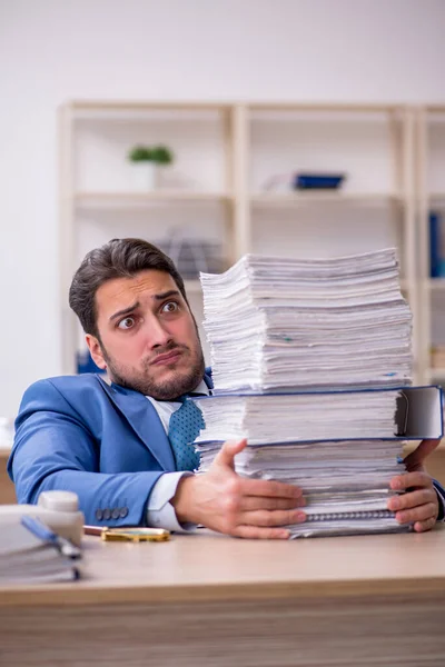 Empleado joven de negocios y demasiado trabajo en la oficina — Foto de Stock