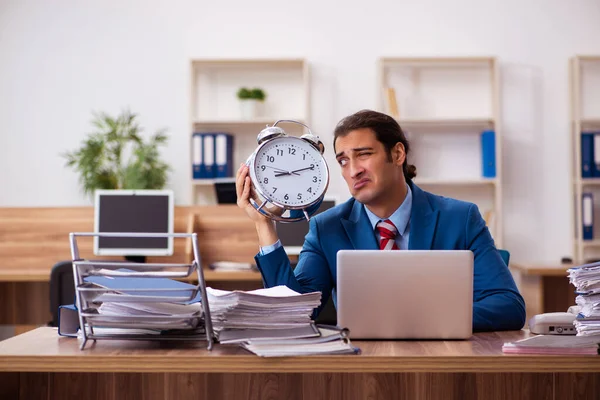 Joven empleado masculino en concepto de gestión del tiempo —  Fotos de Stock