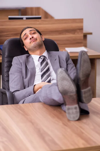 Junger Geschäftsmann sitzt im Büro — Stockfoto