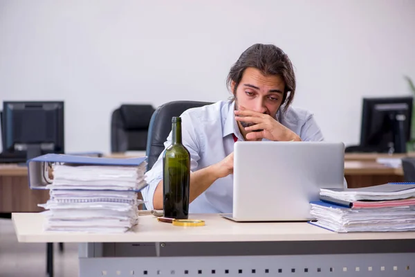 Junge männliche Angestellte trinkt Alkohol im Büro — Stockfoto