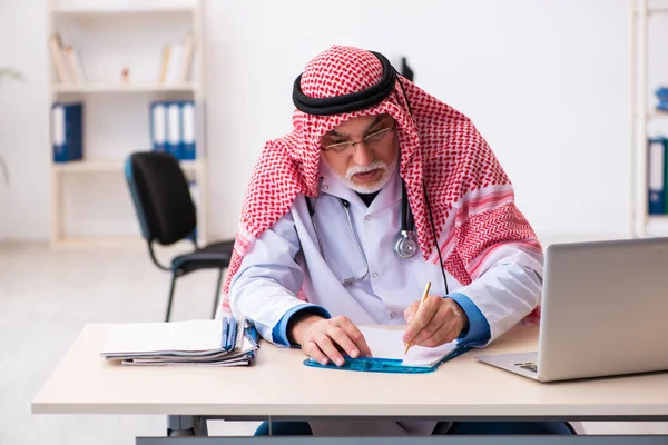 Vecchio medico arabo maschio che lavora in clinica — Foto Stock