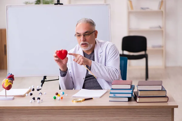 Alte männliche Arzt Kardiologe sitzt im Klassenzimmer — Stockfoto