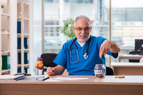 Oude mannelijke cardioloog werkzaam in de kliniek — Stockfoto