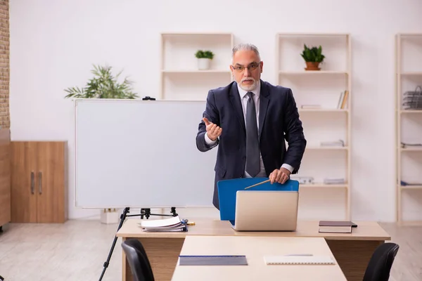 Velho empregador masculino na frente do quadro branco — Fotografia de Stock