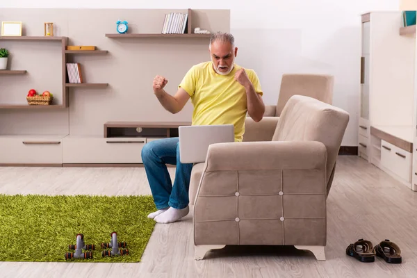 Homem idoso fazendo exercícios esportivos em casa — Fotografia de Stock