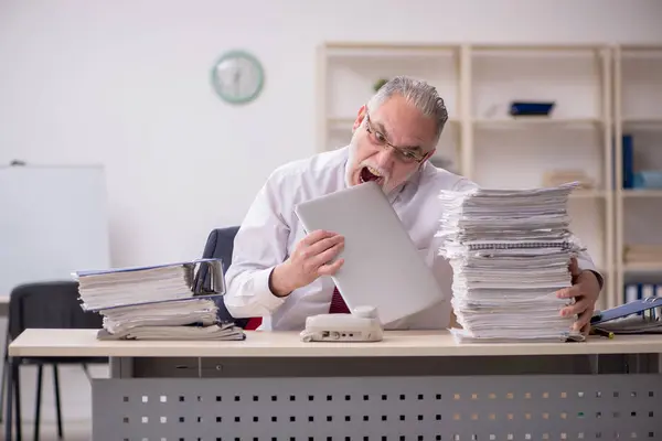 Überalterte männliche Mitarbeiter und zu viel Arbeit am Arbeitsplatz — Stockfoto