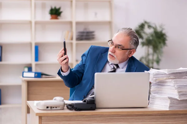 Velho empregado masculino e muito trabalho no escritório — Fotografia de Stock