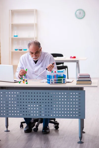 Oude mannelijke chemicus werkt in het lab. — Stockfoto