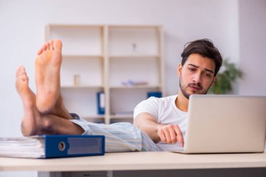 Genç bir erkek işçi yataktan kalkıp işe geliyor.