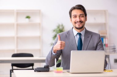 Ofiste çalışan genç bir erkek.