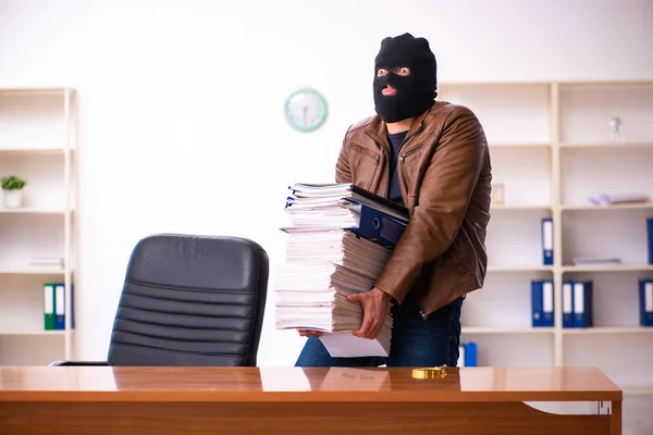 Egy maszkos fiatalember információt lop az irodából. — Stock Fotó