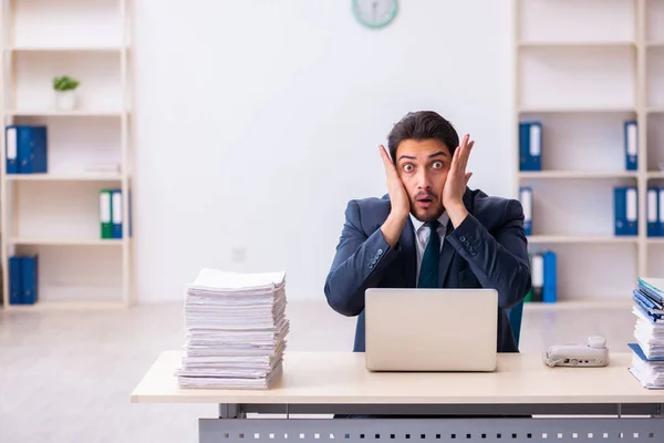 Empleado joven de negocios y demasiado trabajo en la oficina — Foto de Stock