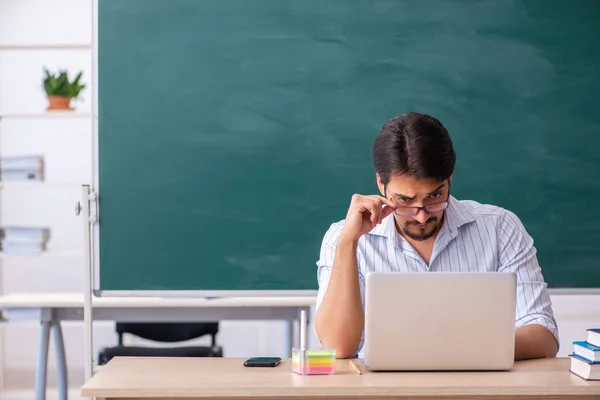 Jonge mannelijke leraar in teleestudie concept — Stockfoto