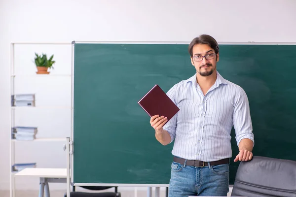 Jeune professeur masculin devant le tableau noir — Photo