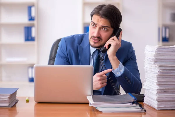 Empleado joven de negocios y demasiado trabajo en la oficina — Foto de Stock