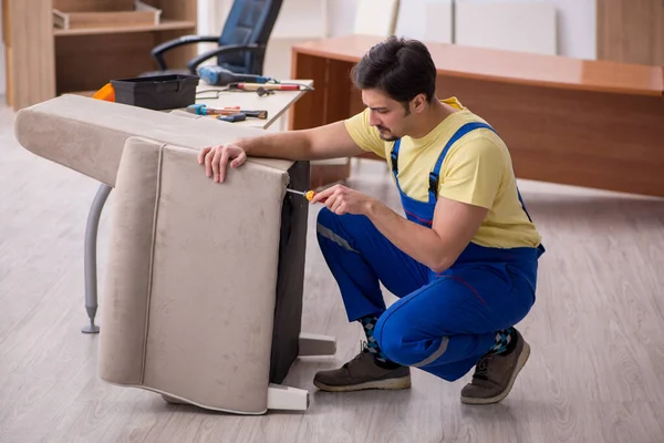 若い男性大工事務所でアームチェアを修理 — ストック写真