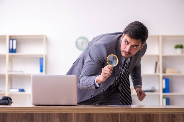 Young handsome auditor working in the office