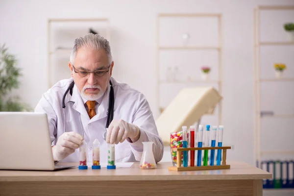 Oude mannelijke arts apotheker werkzaam in de kliniek — Stockfoto
