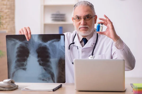 Klinikte çalışan yaşlı bir erkek radyolog. — Stok fotoğraf