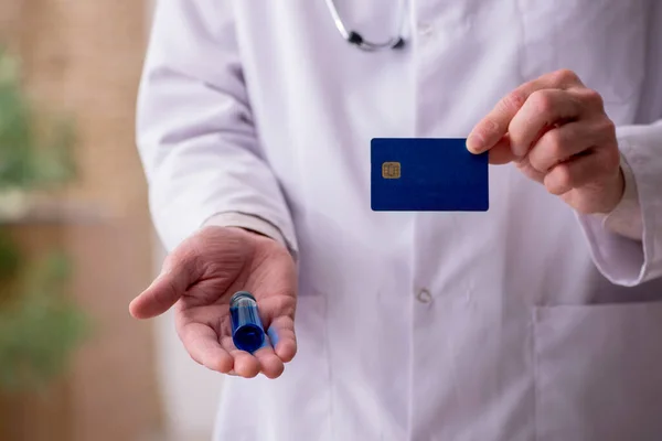Starý lékař drží kreditní kartu — Stock fotografie