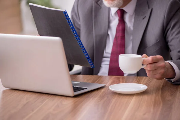 Alte männliche Angestellte trinkt Tee in der Pause — Stockfoto