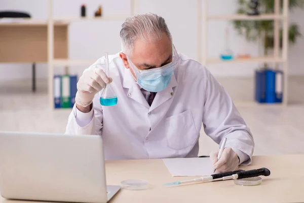 Gammal manlig kemist som arbetar i labbet under pandemin — Stockfoto