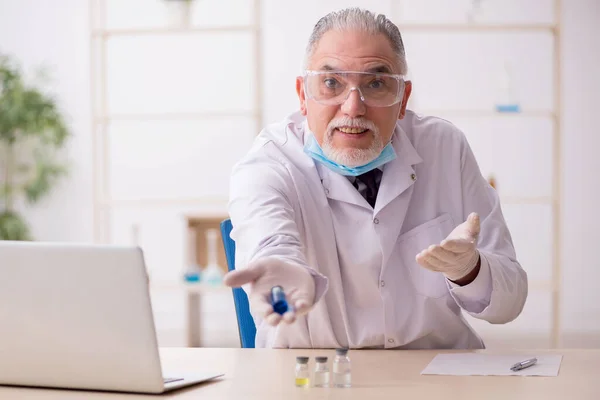 Viejo químico trabajando en el laboratorio durante una pandemia — Foto de Stock