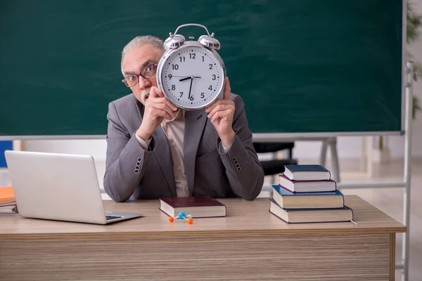 Oude mannelijke leraar in time management concept — Stockfoto