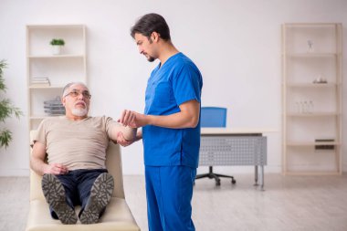 Yaşlı erkek hasta, genç doktor.