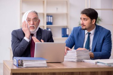 Ofiste diş ağrısı çeken yaşlı bir çalışan.