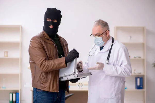 Masked man inbrottstjuv muta gammal läkare för att få vaccin — Stockfoto