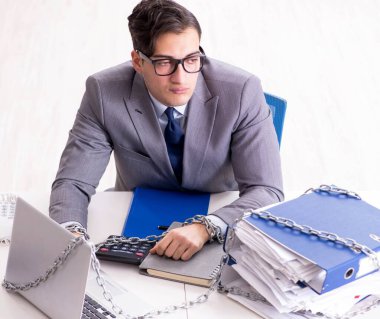 Ofis masasına zincirlenmiş meşgul bir çalışan.