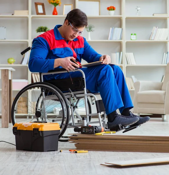 Homem com deficiência que estabelece piso laminado no escritório — Fotografia de Stock